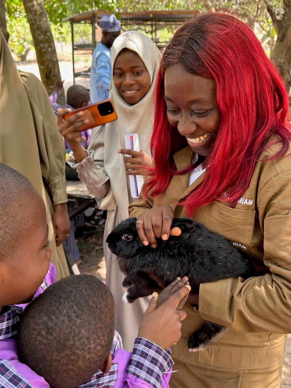 Mariam showing students a rabbit during a farm tour